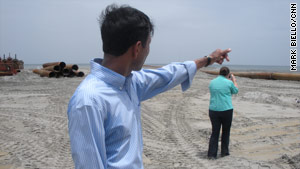 Louisiana Gov. Bobby Jindal points to under-construction sand berms that he says are keeping oil off the shore.