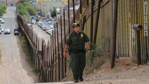 A US Border Patrol officer keeps watch over the border fence that divides the U.S. from Mexico in the town of Nogales, Arizona.