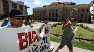 Protesters against the immigration law march past the Arizona state ...