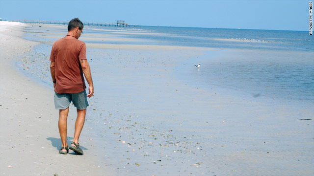 Though the beach has been cleaned up, Clarence Barthel walks alone at Pass Christian, Mississippi, on August 4.