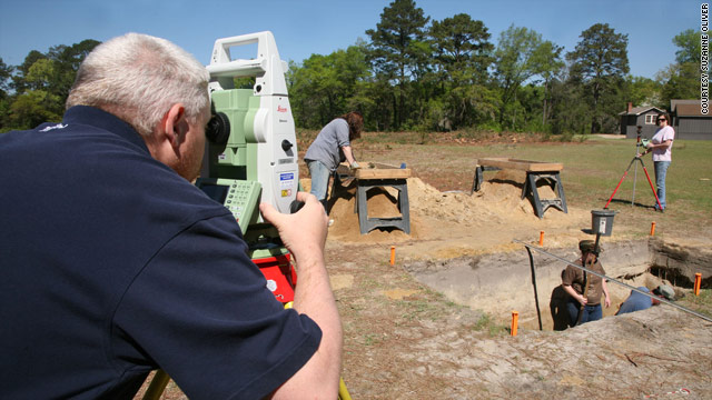 Graduate student Kevin Chapman surveys the Camp Lawton site while other students dig for artifacts in a trench.