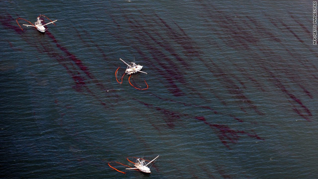 Fishing boats drag booms through oil near a Louisiana barrier island on May 7, two weeks after the Deepwater Horizon sank.