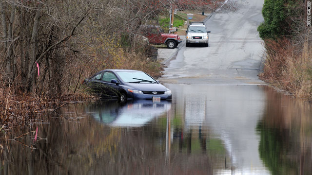 Floodwaters leave a car partially submerged Wednesday in Fall River, Massachusetts, after heavy rainfall in New England.