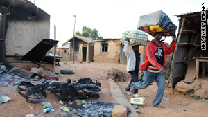 Nigerians flee the city of Kuru Karama on Thursday after religious violence reportedly killed 150 Muslims.