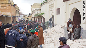 People sift through the rubble of the minaret collapse in Meknes, Morocco, on Friday.