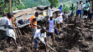 Residents of Mbale dig for bodies; the steep terrain has meant heavy machinery could not be used