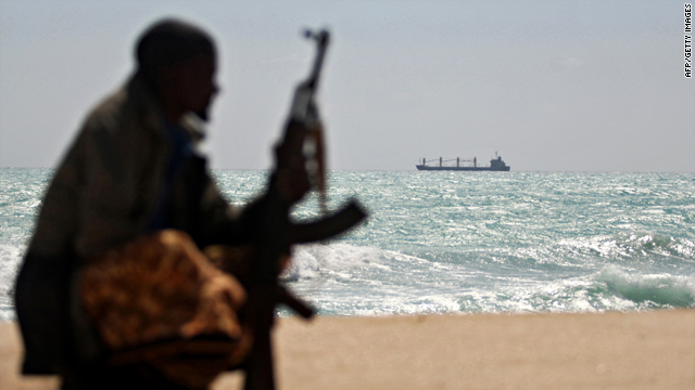 A Somali pirate sits on shore January 7 in northeastern Somalia. Captured Greek vessel the MV Filitsa is in the background.