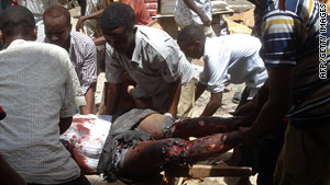 Men evacuate a man wounded Saturday near Bakara market in Mogadishu, Somalia.