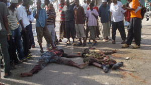 Residents of Mogadishu on Thursday gather around the bodies of two
 army soldiers killed in clashes with Islamists.