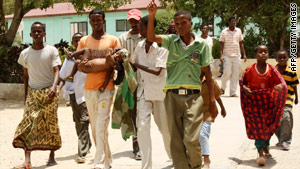 A wounded child is carried by relatives as they arrive at a hospital in Mogadishu on October 6.