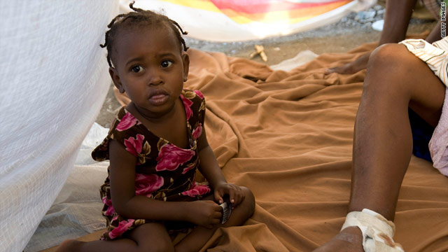 A girl sits by her injured mother in a tent city in Port-au-Prince, Haiti, on Monday.