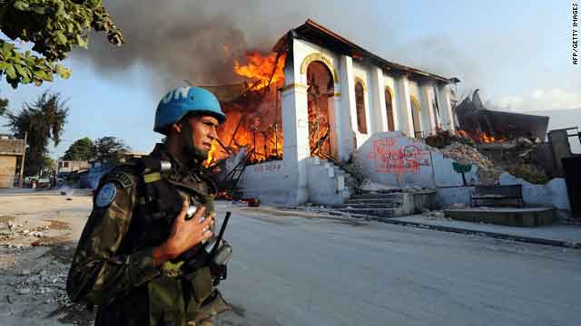 A Brazilian U.N. soldier secures the area around a church that burned Tuesday after collapsing during last week's earthquake.