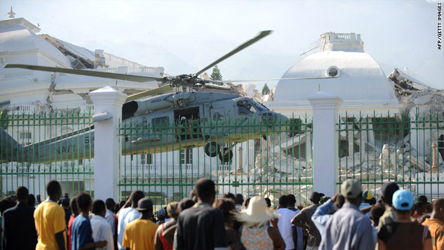 A crowd watches a U.S. Army helicopter land Tuesday on the grounds of Haiti's ruined Presidential Palace.