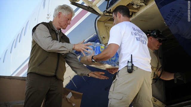 Bill Clinton takes bottles of water out of his plane January 18 at the international airport for Port-au-Prince, Haiti.