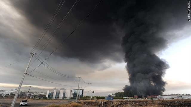 Smoke from a large fire towers into the sky outside Santiago, Chile, after Saturday morning's earthquake.