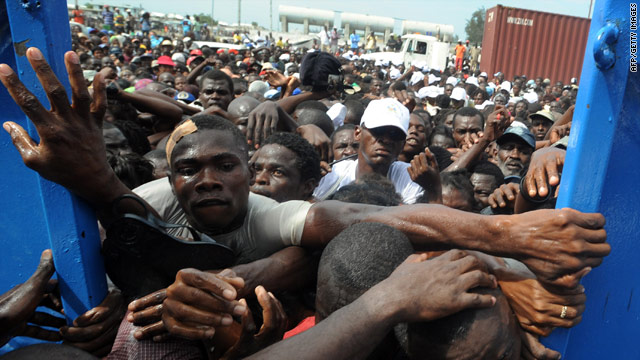 Haitians desperately try to enter the police station where an aid distribution point has been set up in Port-au-Prince.