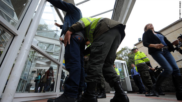 A Colombian police officer frisks a citizen during the presidential election runoff Sunday in Bogota, Colombia.