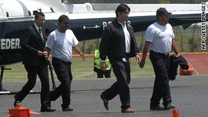 Two freed journalists (in white T-shirts) are escorted from a helicopter in Mexico City, Mexico, on Saturday.