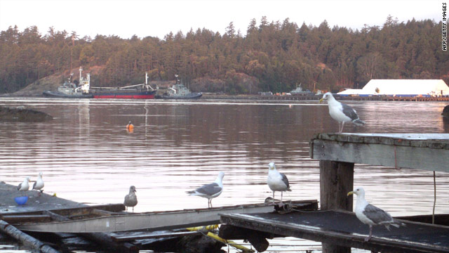Two Canadian navy tugboats guide MV Sun Sea, suspected of carrying 490 Tamil migrants, into dock on August 13, 2010.
