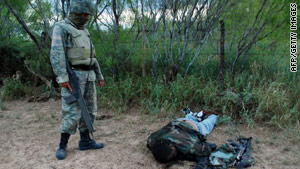 A Mexican soldier stands over one of the 25 drug suspects killed Thursday in a shootout in northeast Mexico.