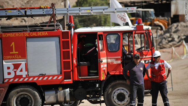 Firefighters stand by near the San Jose mine at Copiapo, Chile, Thursday as rescuers closed in on 33 trapped miners.