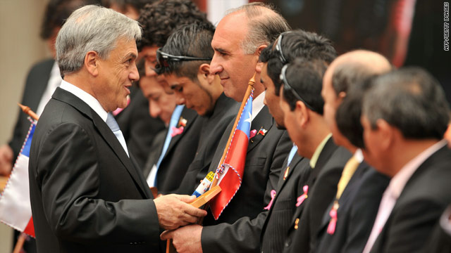 Chilean President Sebastian Pinera gives a gift to miner Jose Henriquez at a ceremony in Santiago on Monday.