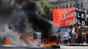 Protesters wave flags and burn tyres at 9 de Julio Avenue in Buenos Aires on December 20.