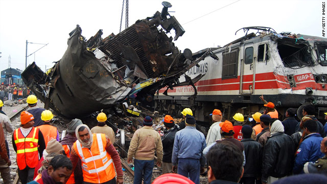 A damaged coach is moved from the wreckage Saturday after a deadly collision near Kanpur, India.