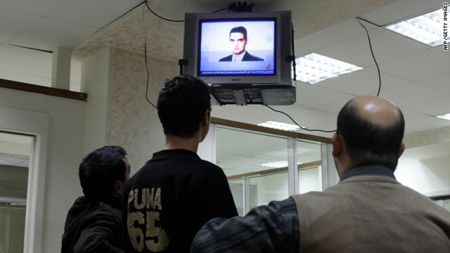 Employees look at a picture of Jordanian Humam Khalil Abu-Mulal al-Balawi broadcast by the Qatar-based Al-Jazeera satellite news channel at an office in the Jordanian capital Amman on January 6, 2010.