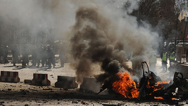 afghan police watch the flames after a suicide attack blamed