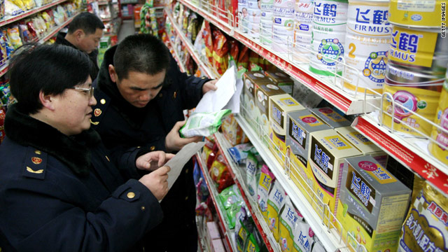 Health enforcement officers check labels on milk powders at a store in east China's Anhui province.