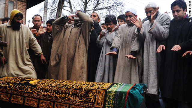 Men pray over the coffin of Zahid Farooq Sheikh at his funeral in Srinagar on February 6, 2010.