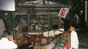 Onlookers stand near the wreckage of the blast-hit bakery in the city of Pune in western India.