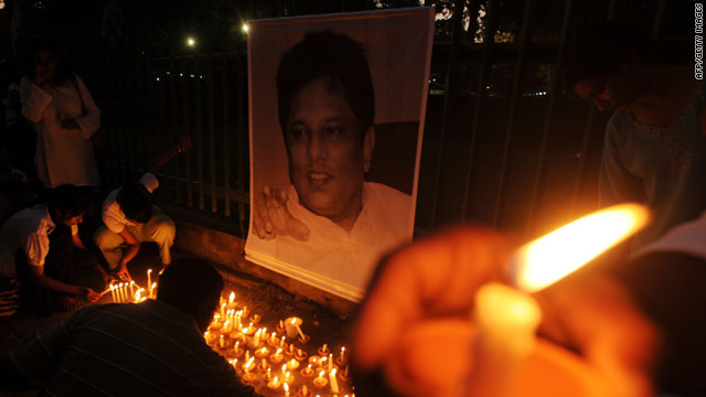 Sri Lankan journalists and well wishers light candles in front of a photograph of Lasantha Wickrematunge in Colombo.