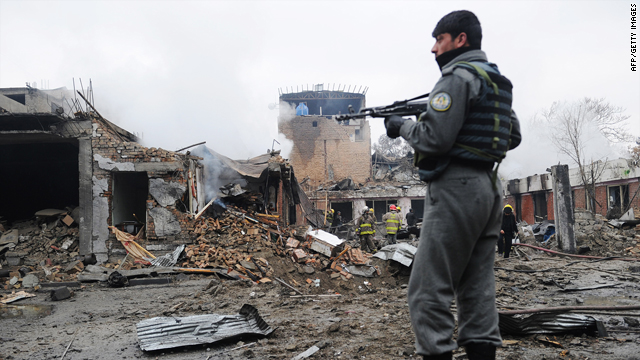 An Afghan security officer stands guard as firemen inspect the debris at the site of a blast in the Shahr-E-Naw area in the heart of the capital Kabul on Friday.