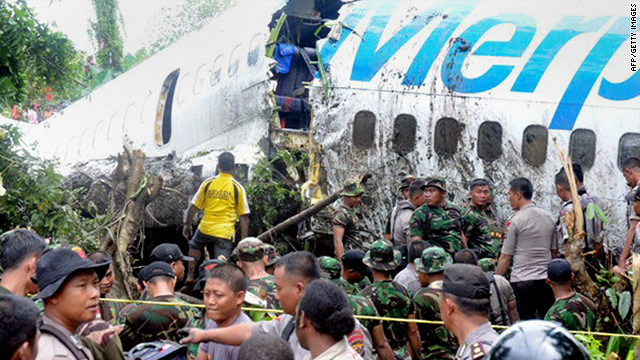 Soldiers and police examine a Merpati Airline 737 after it skidded off the runway on landing in Manokwari, Indonesia, Tuesday.