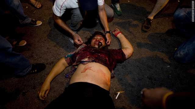 An injured Thai lies on the ground after a blast was heard in the financial district of central Bangkok Thursday.