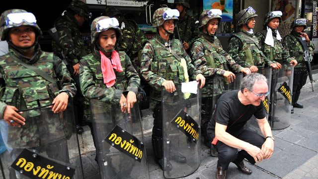 A foreign tourist poses in front of Thai soldiers near the anti-government protester camp in Bangkok on Saturday.