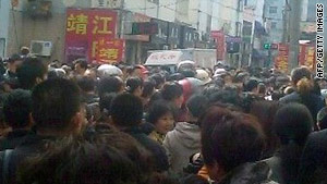 A crowd gathers outside a kindergarten in China Thursday where a man attacked more than two dozen children.