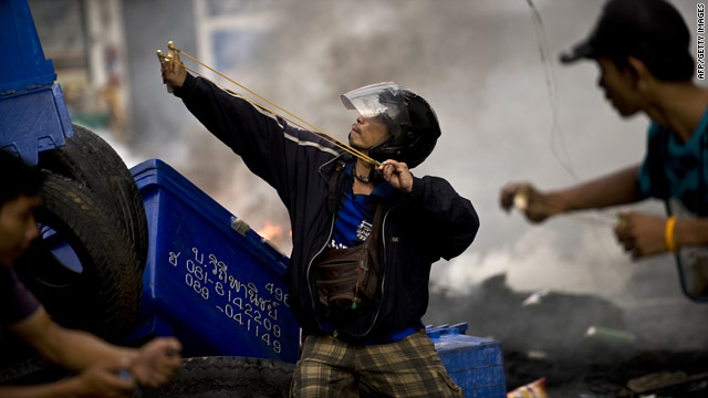 Thai demonstrators use slingshots to launch stones against security forces during clashes in Bangkok on May 16, 2010.