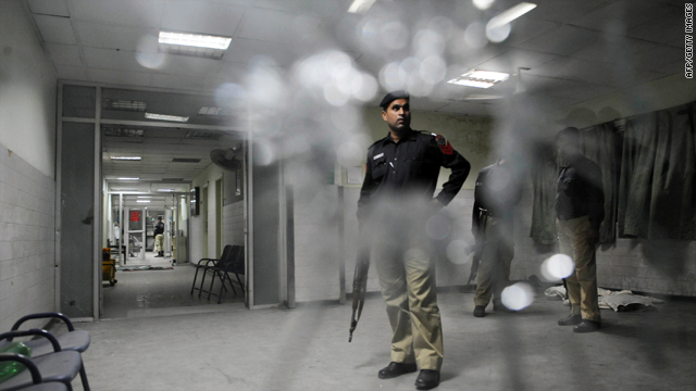 Pakistani policemen search a hospital following the attack at the Jinnah Hospital in Lahore on Tuesday.