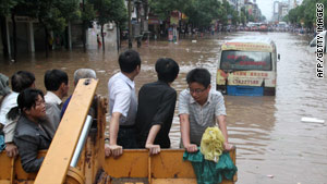 Evacuated families arrive by trucks and tractors at a relief center in Dongxiang, China, on Sunday.