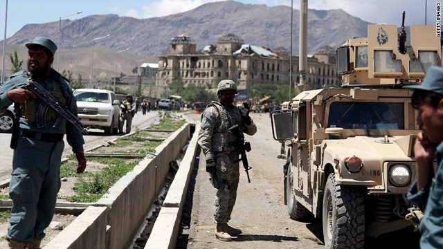 Investigators inspect the site of a suicide car bomb attack on May 18 in Kabul, Afghanistan. The U.S. military is investigating whether  taxpayer money is being used to pay off insurgents in return for not attacking contractors