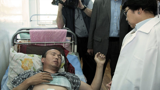 Kyrgyzstan's interim government leader Roza Otunbayeva speaks to a wounded ethnic Kyrgyz citizen in Osh on June 18, 2010.