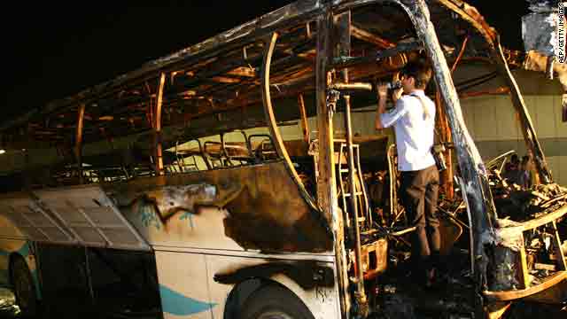 A Chinese policeman checks the burned-out bus on a road in Wuxi, China, in Jiangsu province on Monday.
