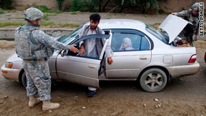 U.S. Marines search a car at a checkpoint in Bagram, Afghanistan, on Wednesday.