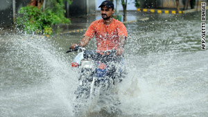 A Pakistani motorcyclist rides through a flooded street during heavy monsoon rains in Karachi.