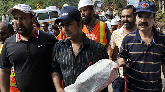 A Pakistani official carries the black box from the crashed Airblue passenger plane at the Margalla Hills on the outskirts of Islamabad on July 31, 2010.