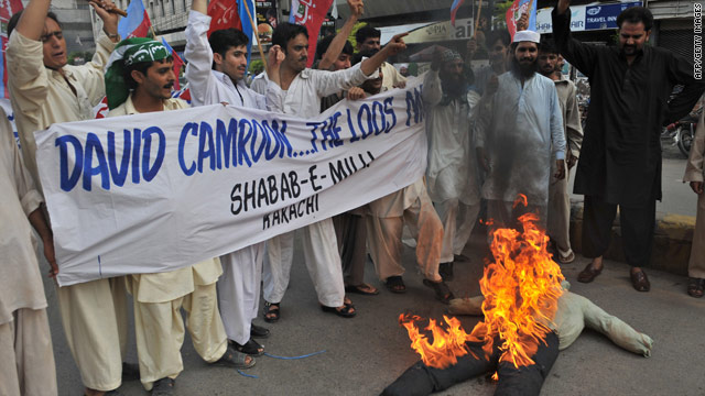 slamic activists burn an effigy of British Prime Minister David Cameron during demonstrations in Karachi.