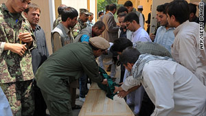 Friends and family attend to the coffin of a slain Afghan aid worker this week at a Kabul, Afghanistan, morgue.